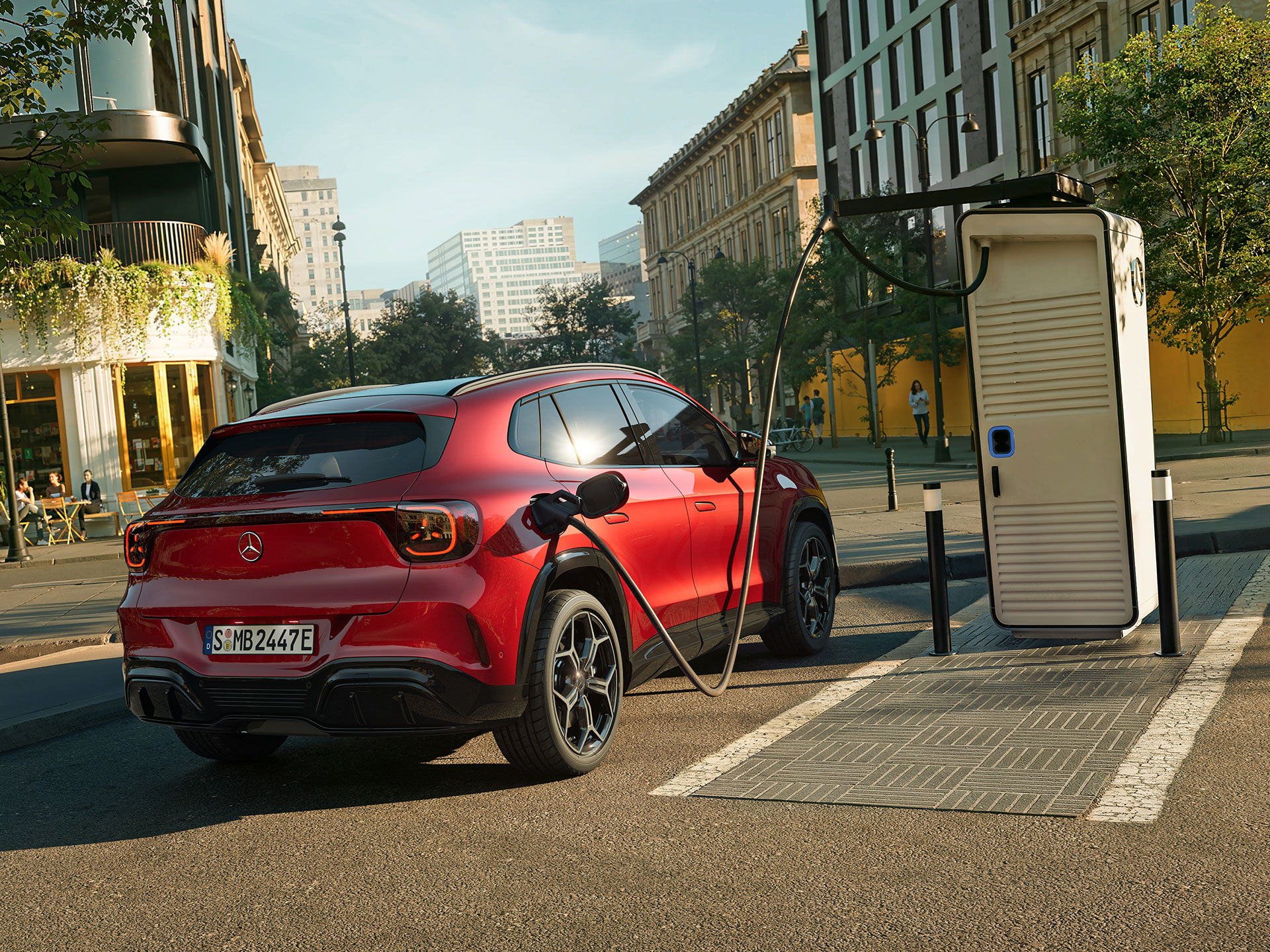 Range & Charging | The all-new electric GLA | Mercedes-Benz The all-new electric GLA from Mercedes-Benz standing next to a charging station while charging.