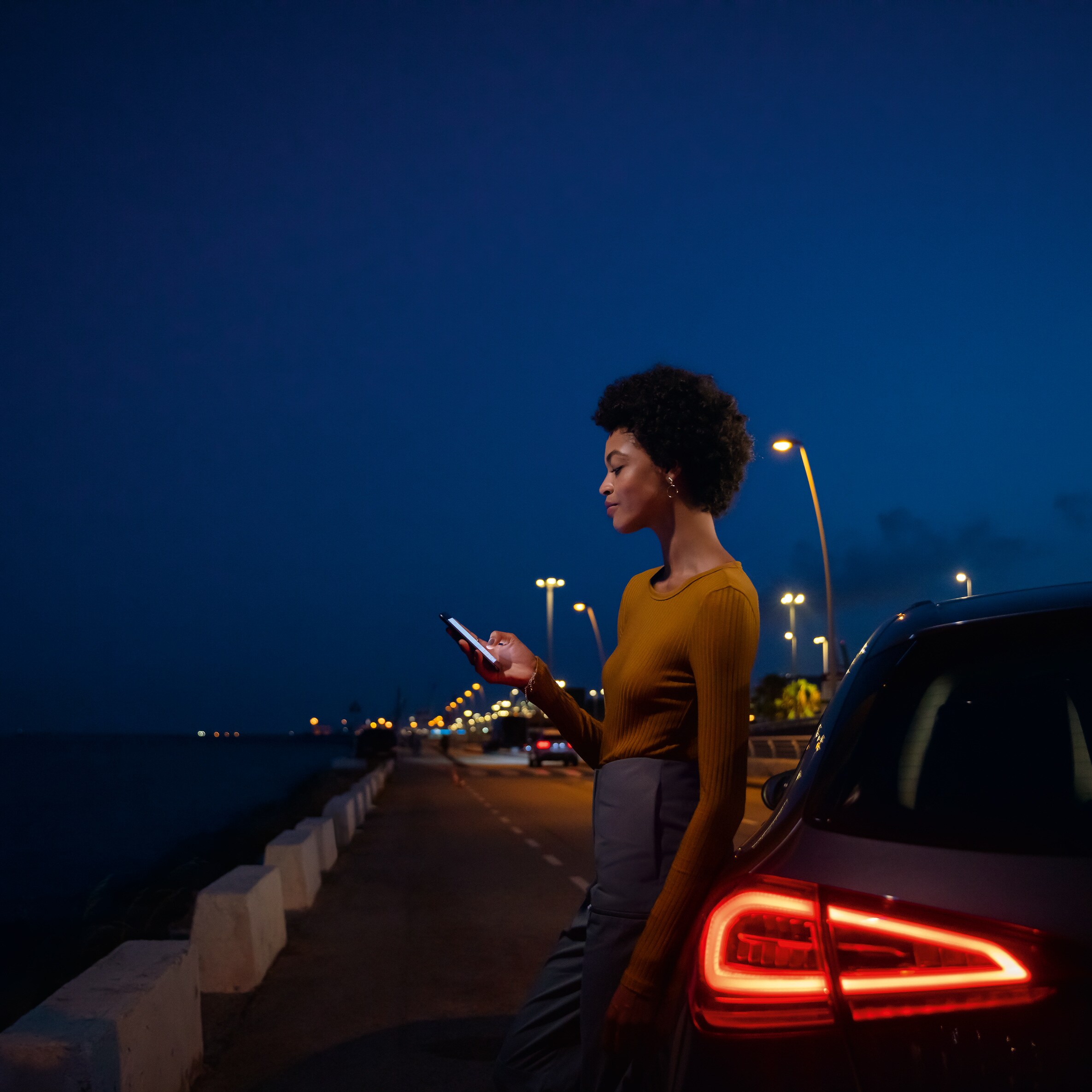 Lady on her phone at the side of the road