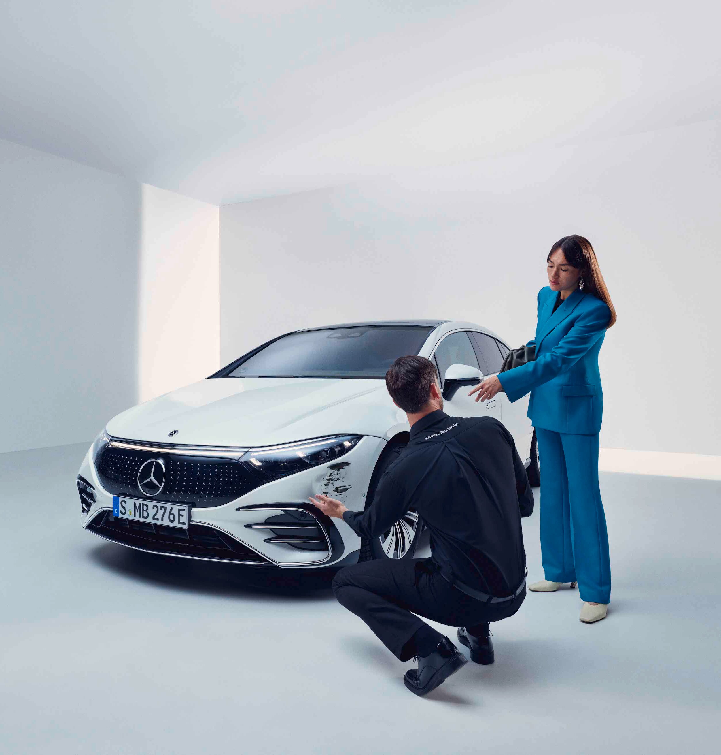 A woman has her Mercedes-Benz checked out by a service employee.