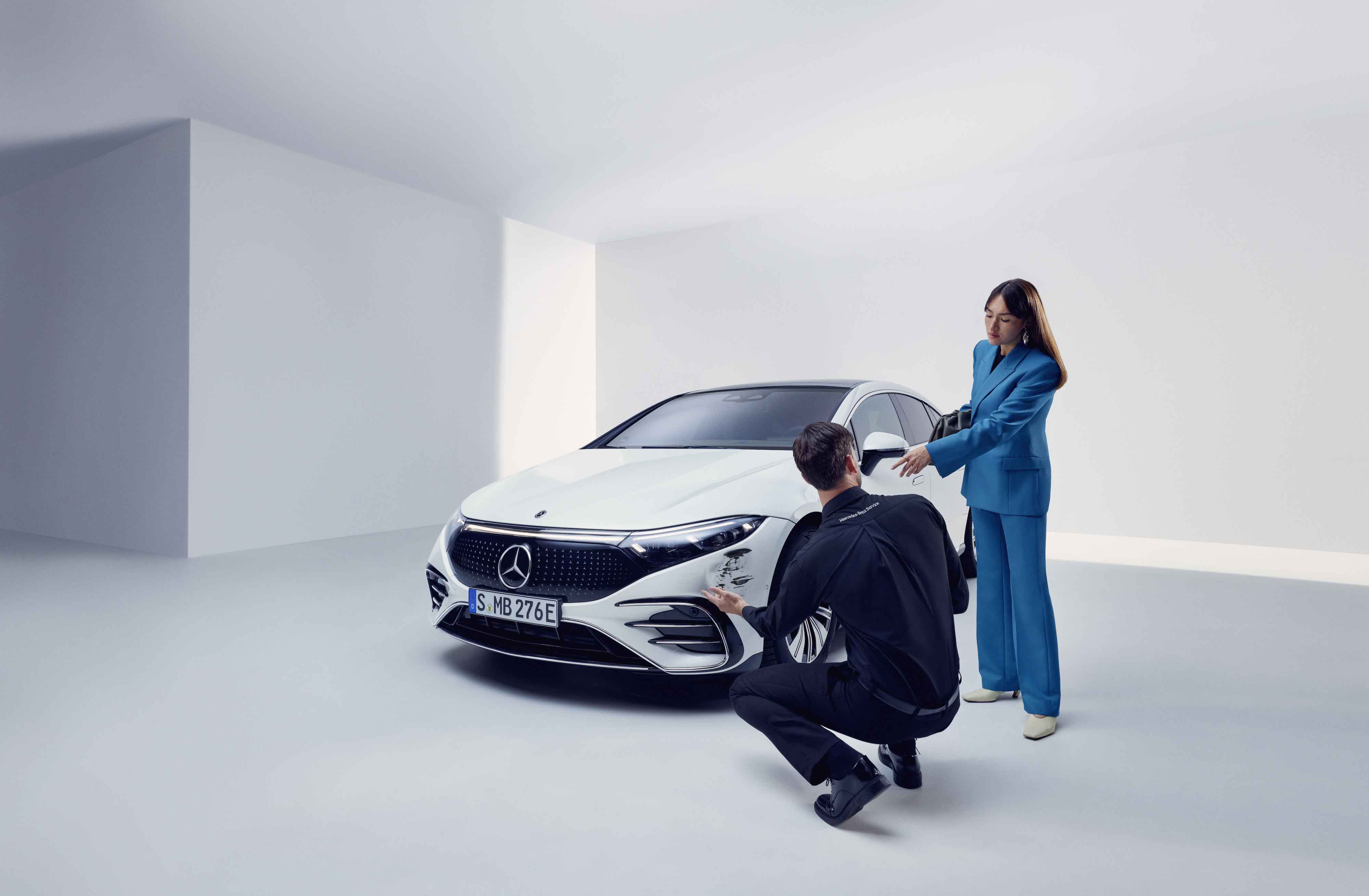Damage Assistance | Mercedes-Benz A woman has her Mercedes-Benz checked out by a service employee.