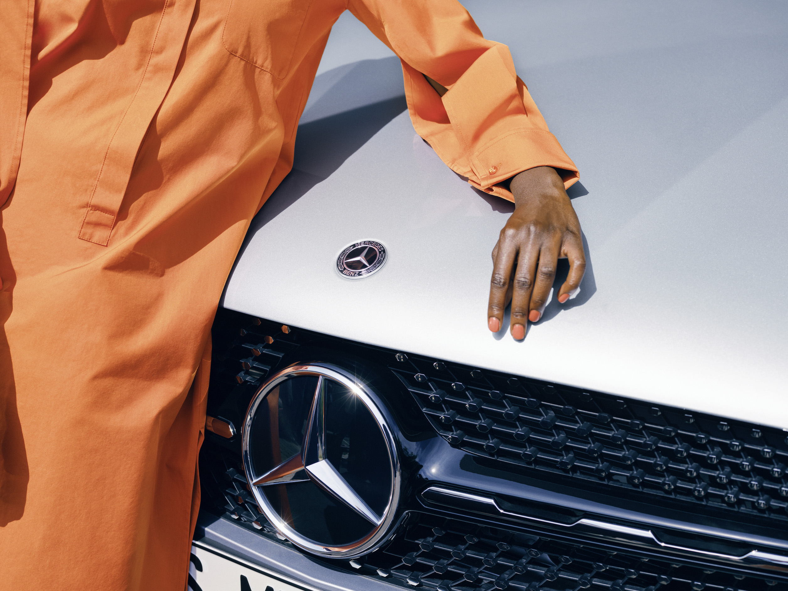 Mercedes-Benz | Genuine Car Care Products A woman admires the paintwork on her Mercedes-Benz.