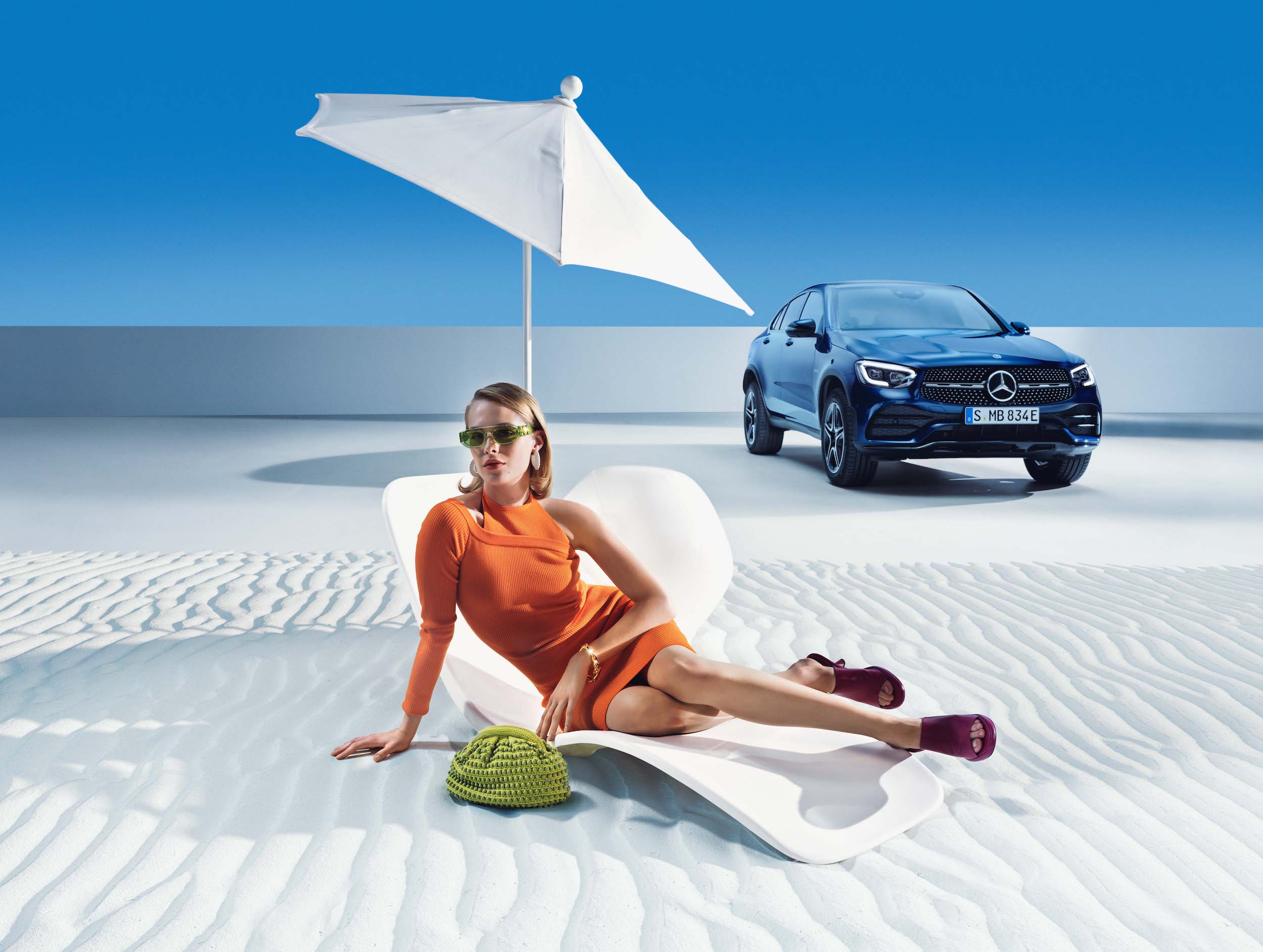 Mercedes-Benz | Genuine Car Care Products A woman relaxing on the beach, next to her Mercedes-Benz.