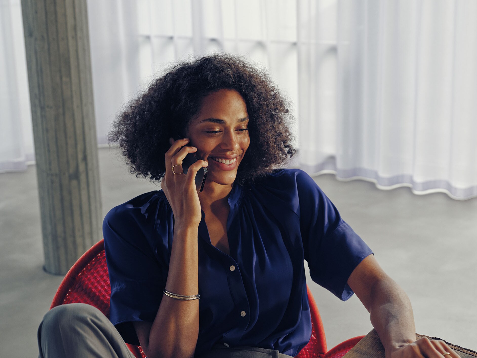 A woman sitting at a table talking on the phone.