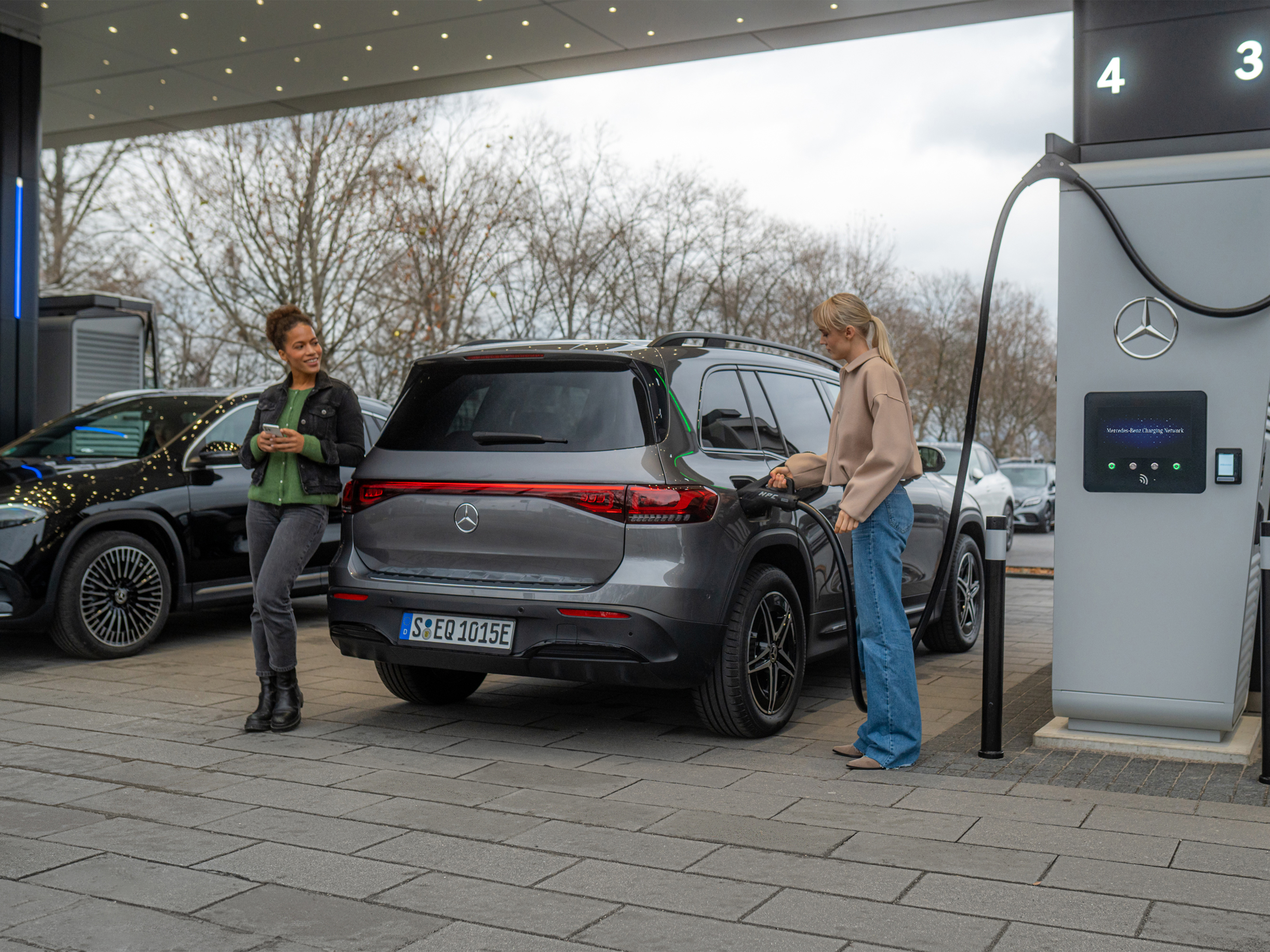 Mercedes-Benz Charging Network | Charging on the go | Mercedes-Benz Two Mercedes-Benz electric cars at a charging station.