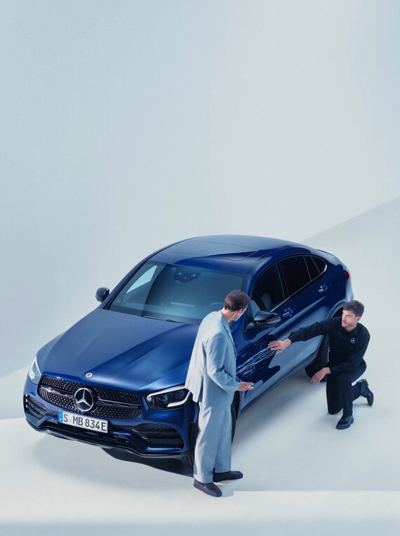 Man from the Mercedes-Benz support Team kneelig by a damaged Mercedes-Benz 