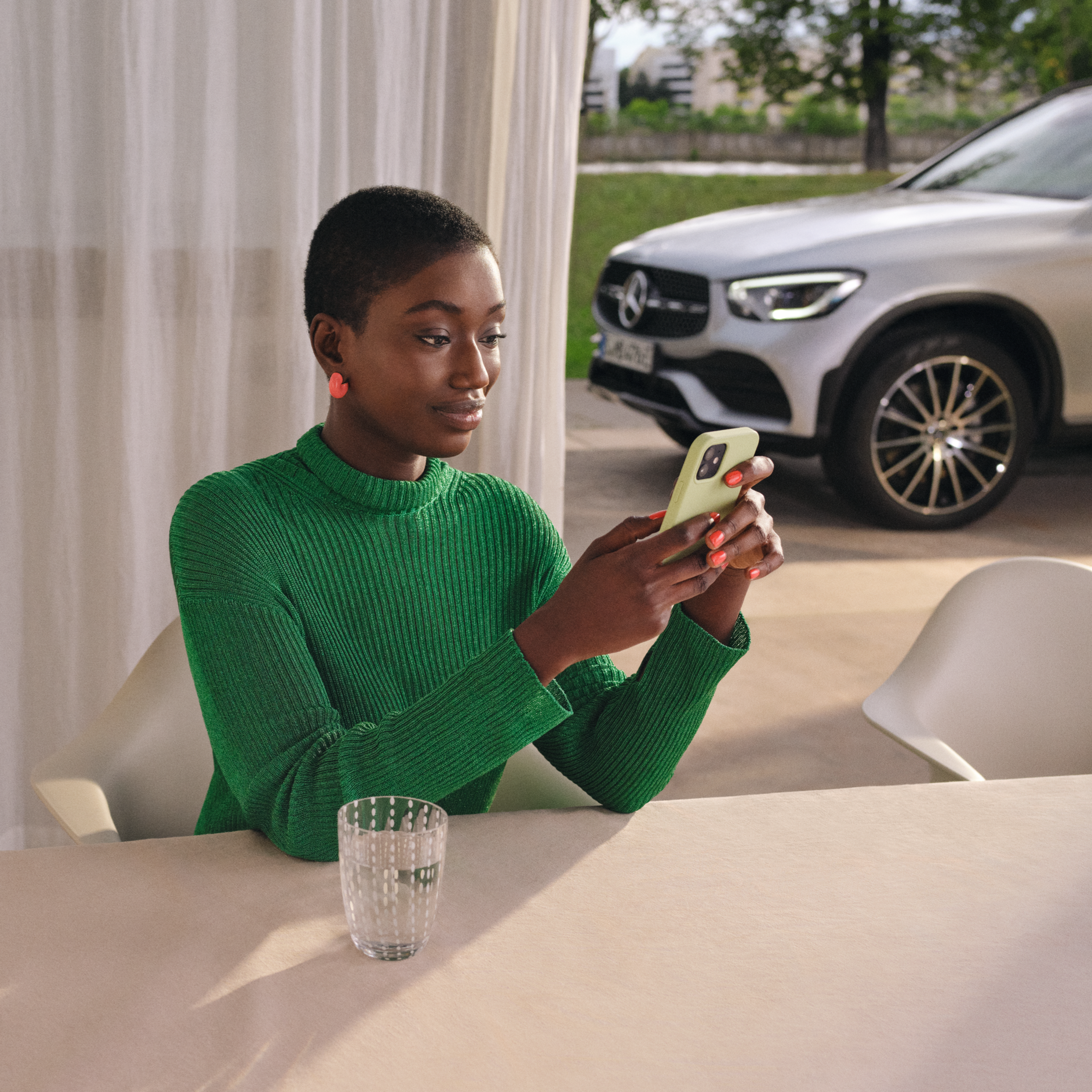 Telediagnostics | Standard Services | Mercedes me Woman checking the status of her vehicle on her smartphone.