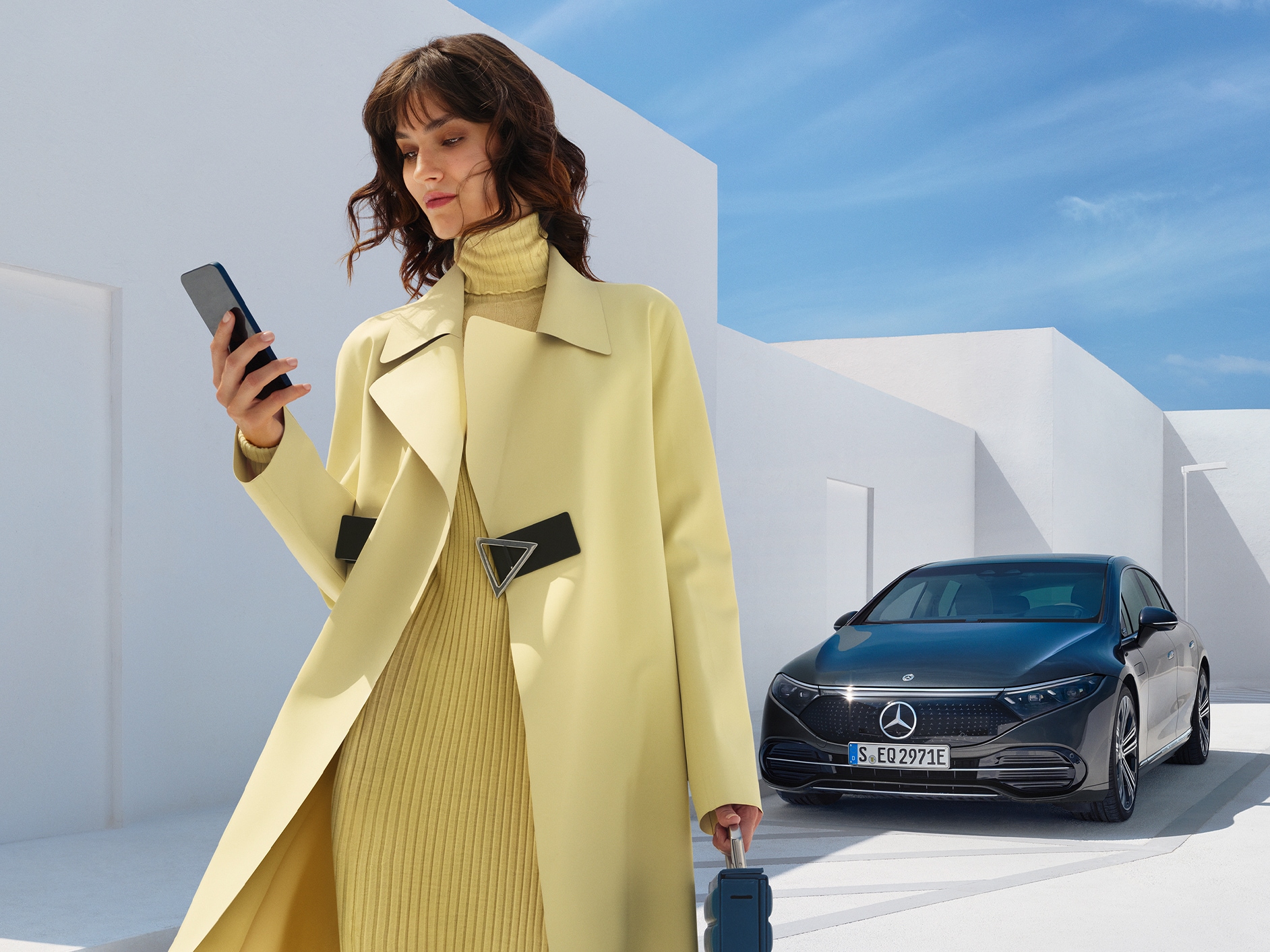 A woman standing in front of the EQS Saloon from Mercedes-Benz.