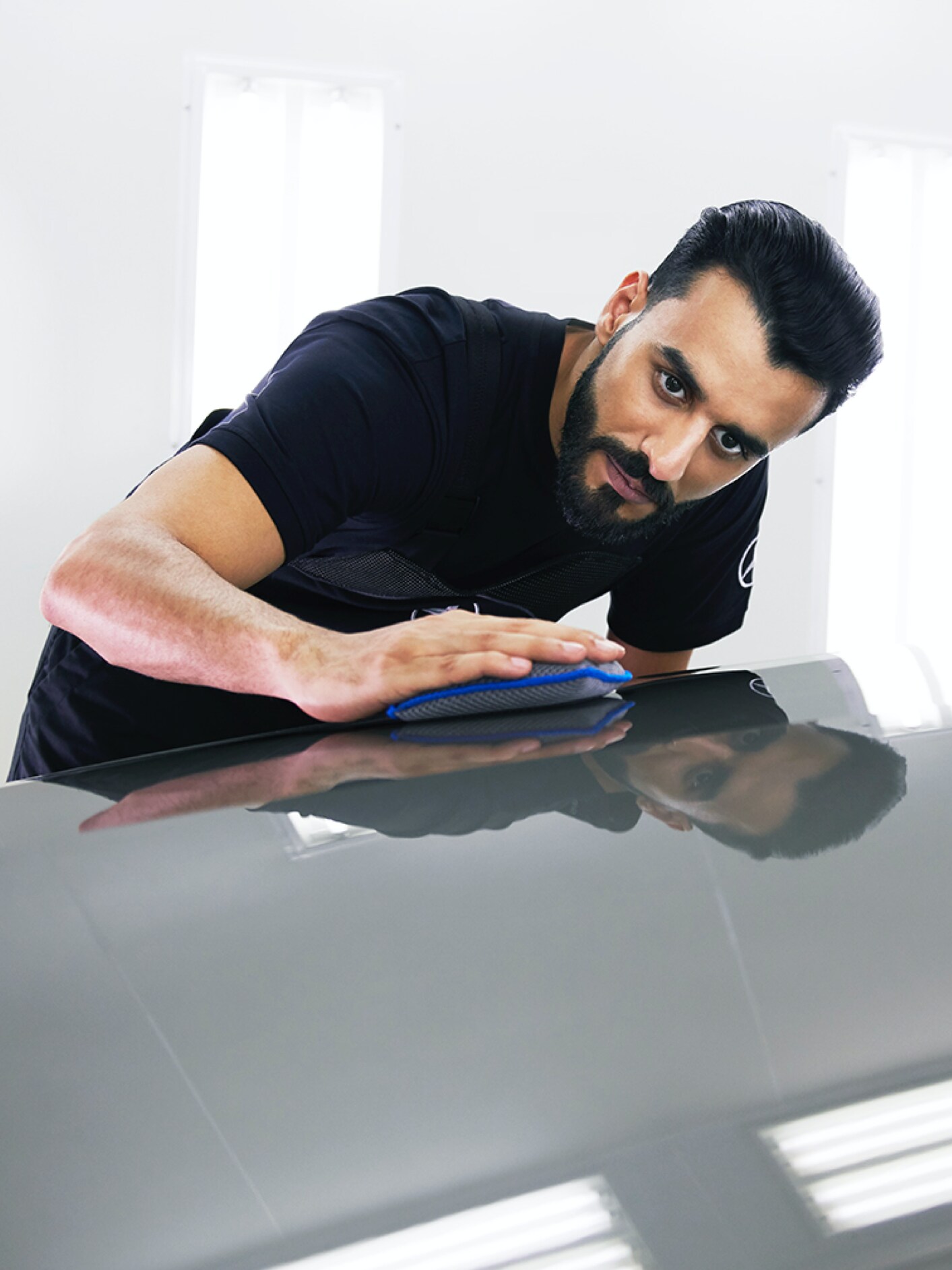 A Mercedes-Benz technician checks the bonnet for minor damage.