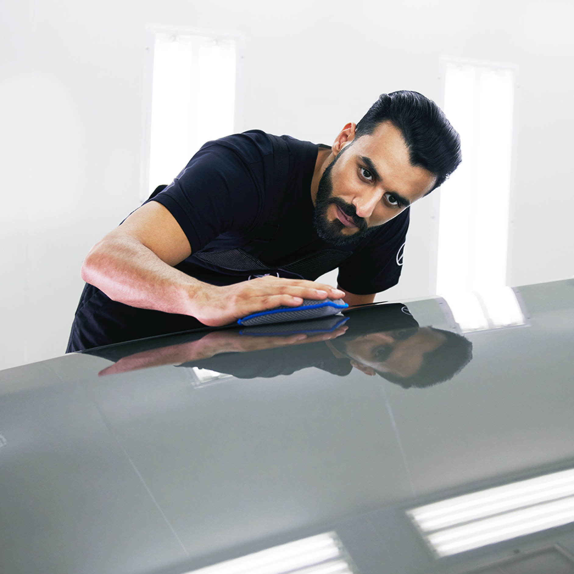 SmallRepair A Mercedes-Benz technician checks the bonnet for minor damage.