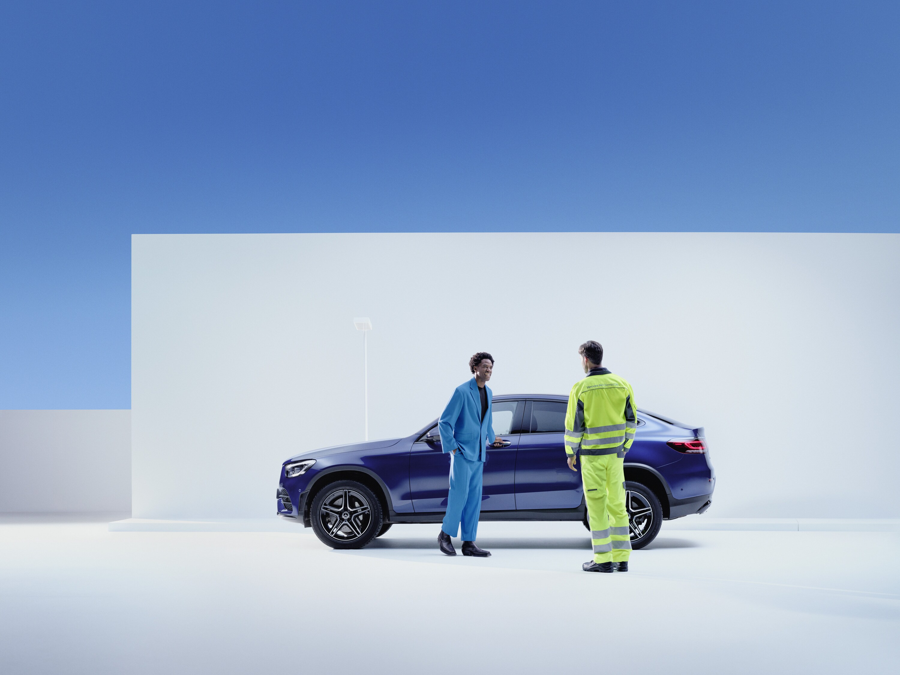 Mercedes-Benz service Person stands next to a man on the side of his Mercedes-Benz 