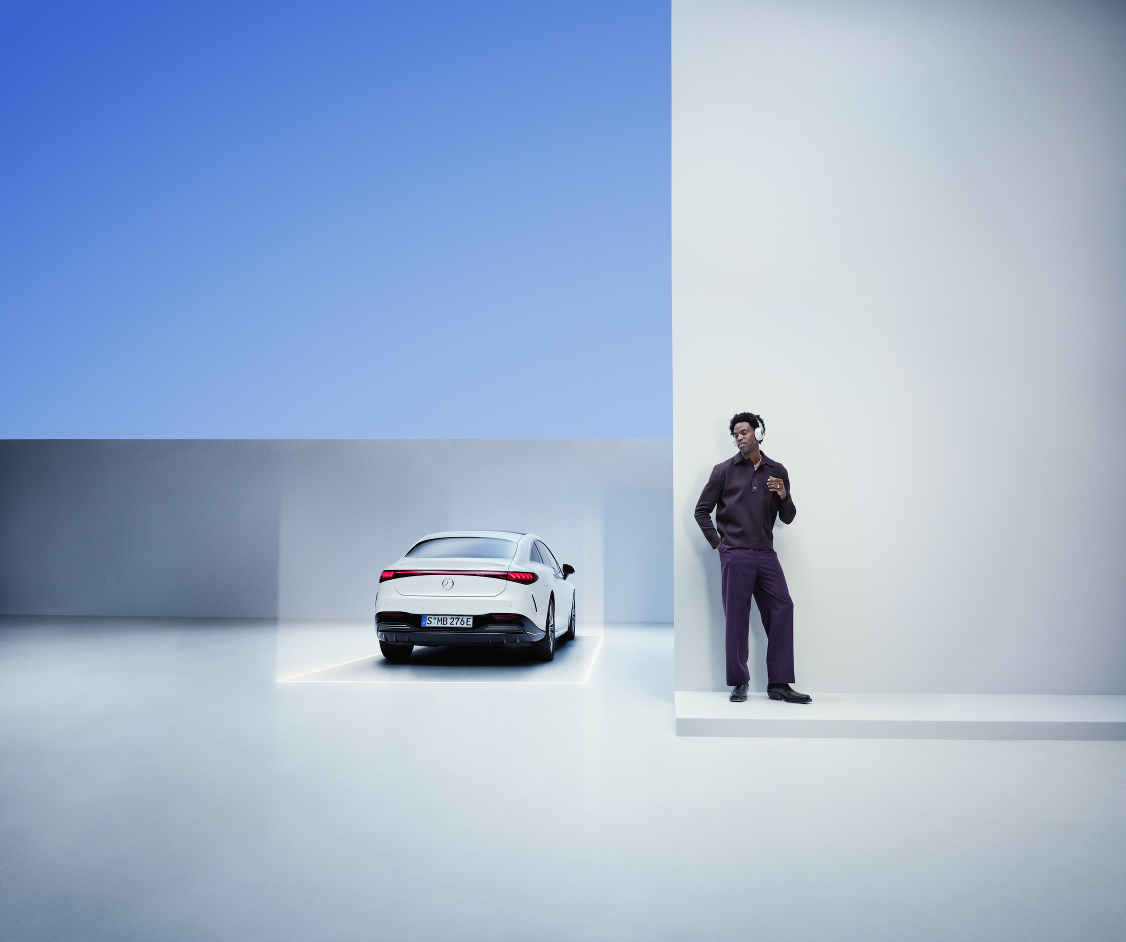 Mercedes-Benz ServiceCare A man leans against a wall next to a Mercedes-Benz.