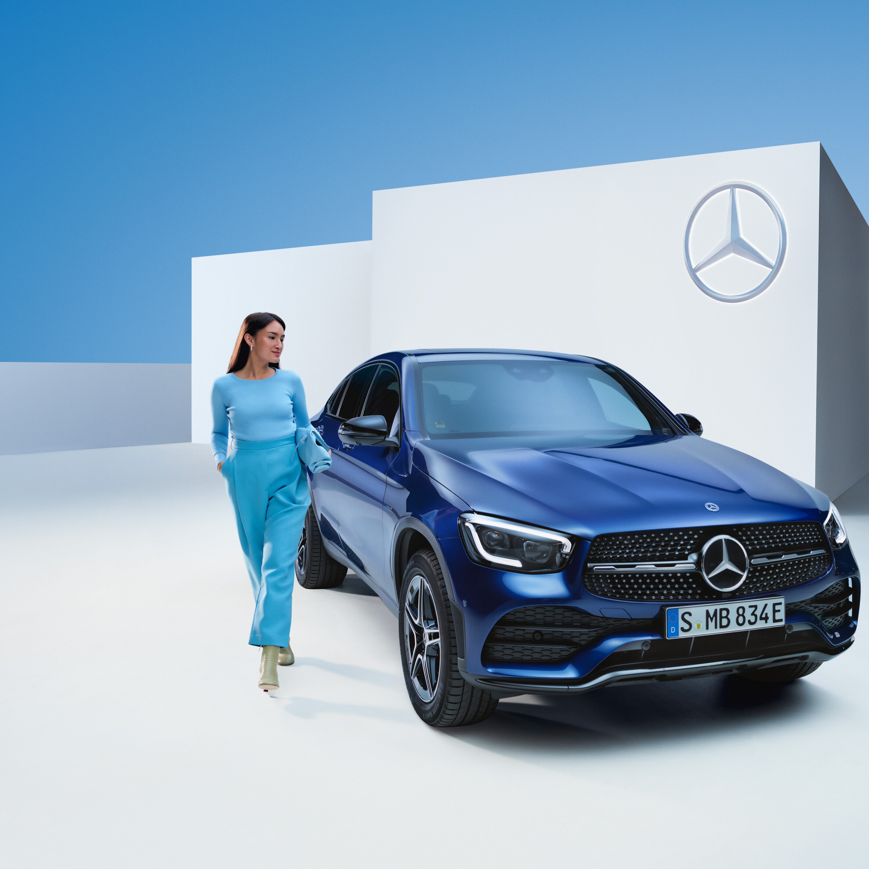 A relaxed woman at the wheel of her Mercedes.
