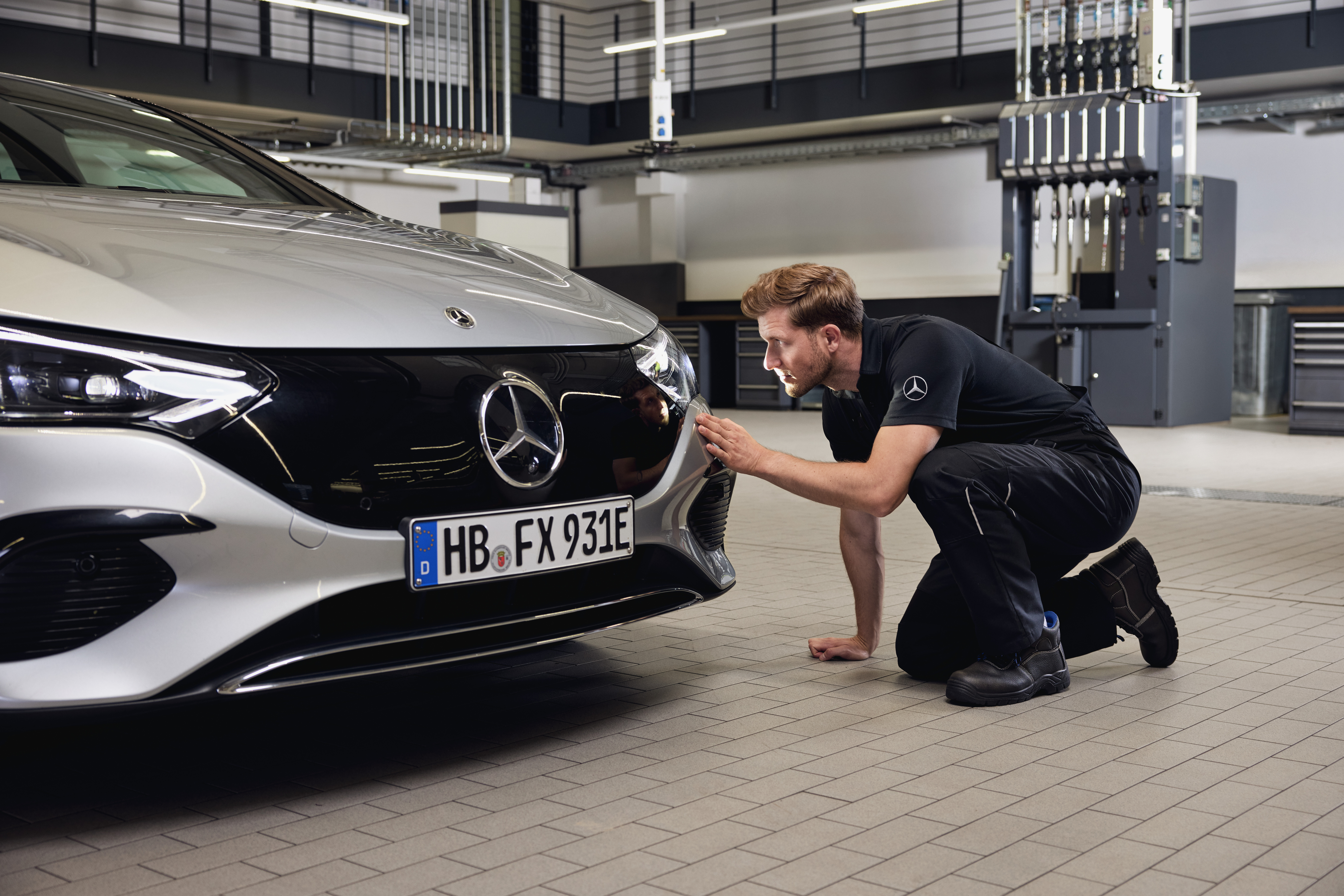 Mercedes-Benz Genuine Headlights Replacement Close‑up of a Mercedes‑Benz vehicle front with a technician performing a detailed examination on the replacement of Mercedes-Benz genuine parts.