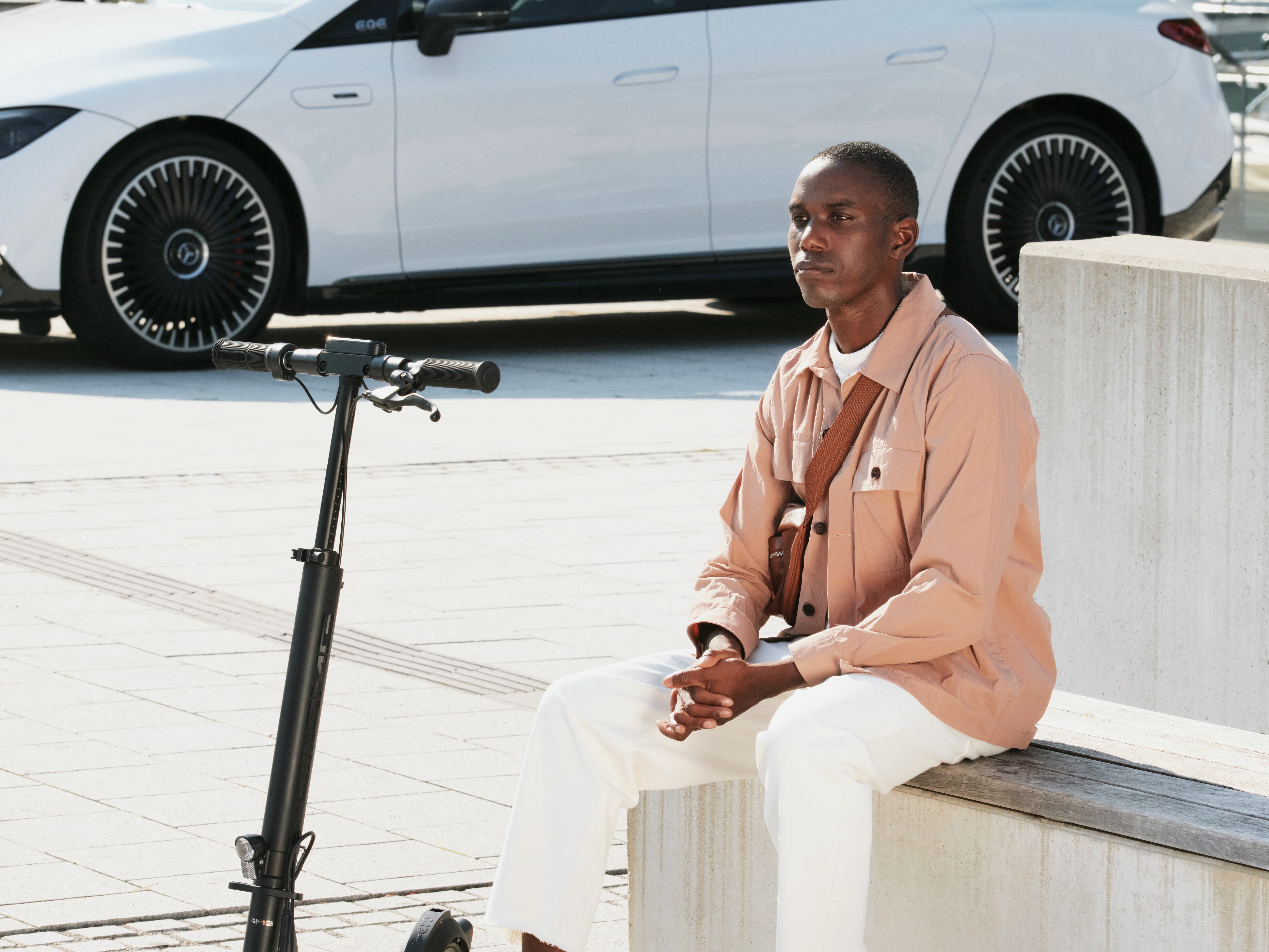 A Mercedes-Benz e-scooter against a backdrop of a city skyline.
