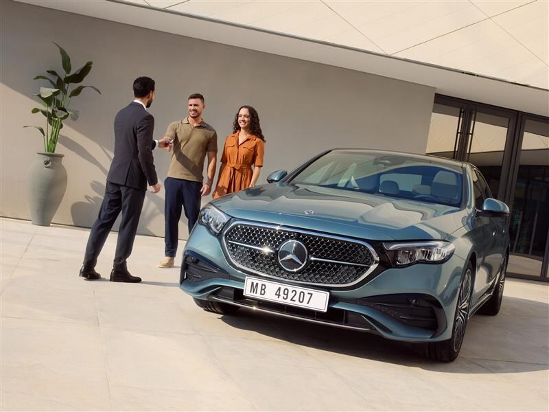 Woman in a blue blazer looking inside the car 
