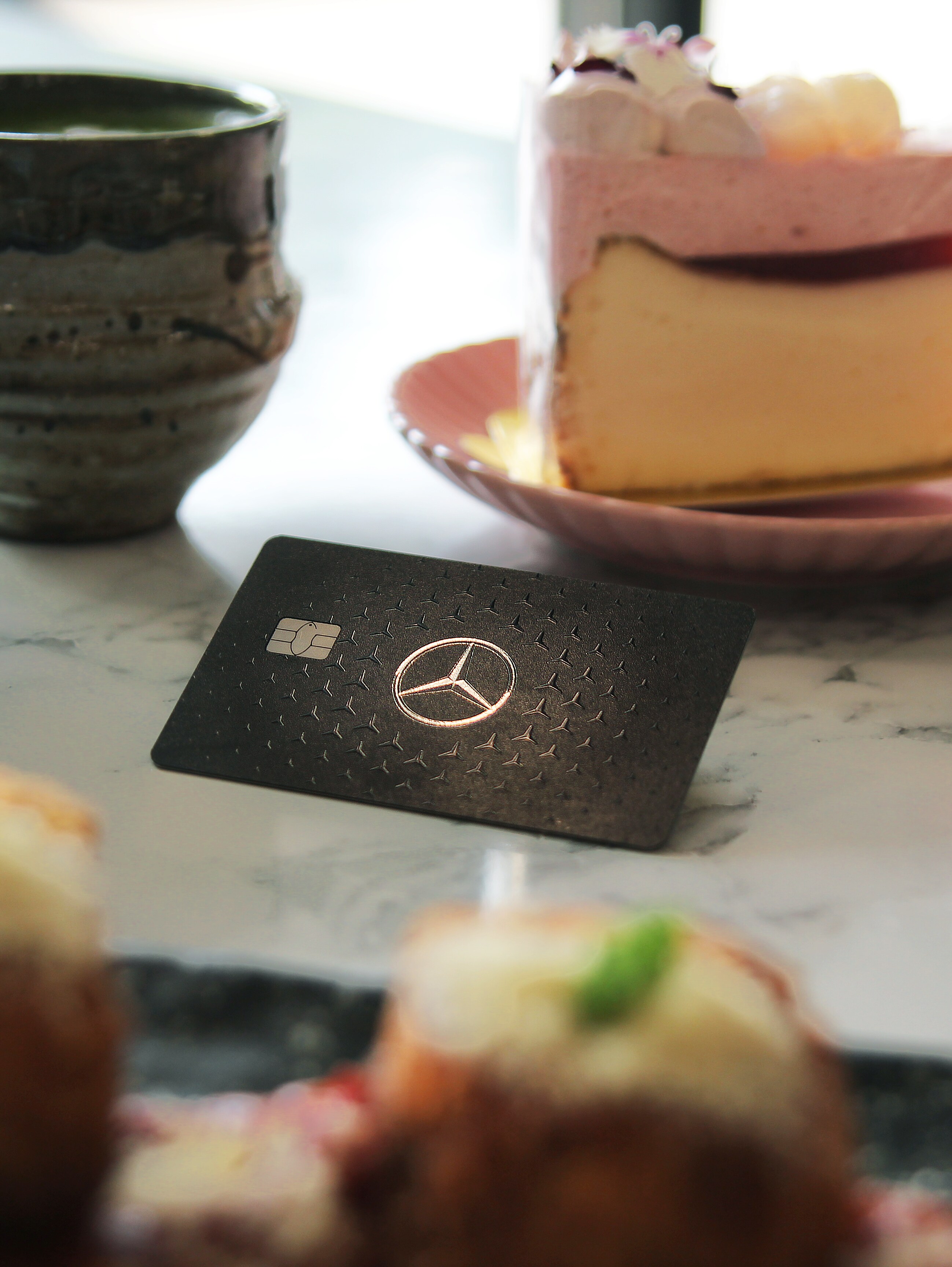 A Mercedes-Benz card on a dining table surrounded by food