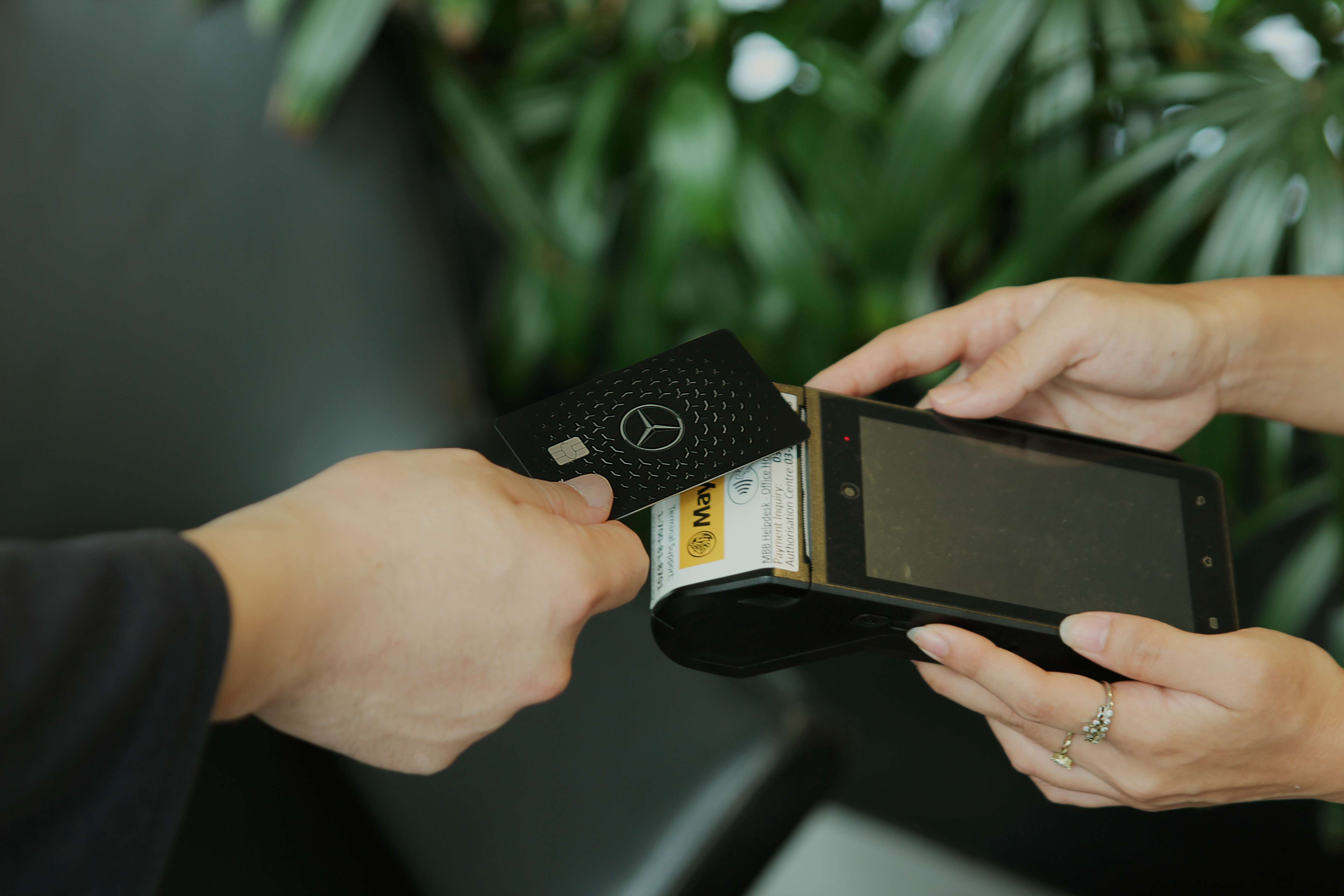 Mercedes-Benz Card | Brand | Mercedes-Benz A man making a payment with a Mercedes-Benz Card