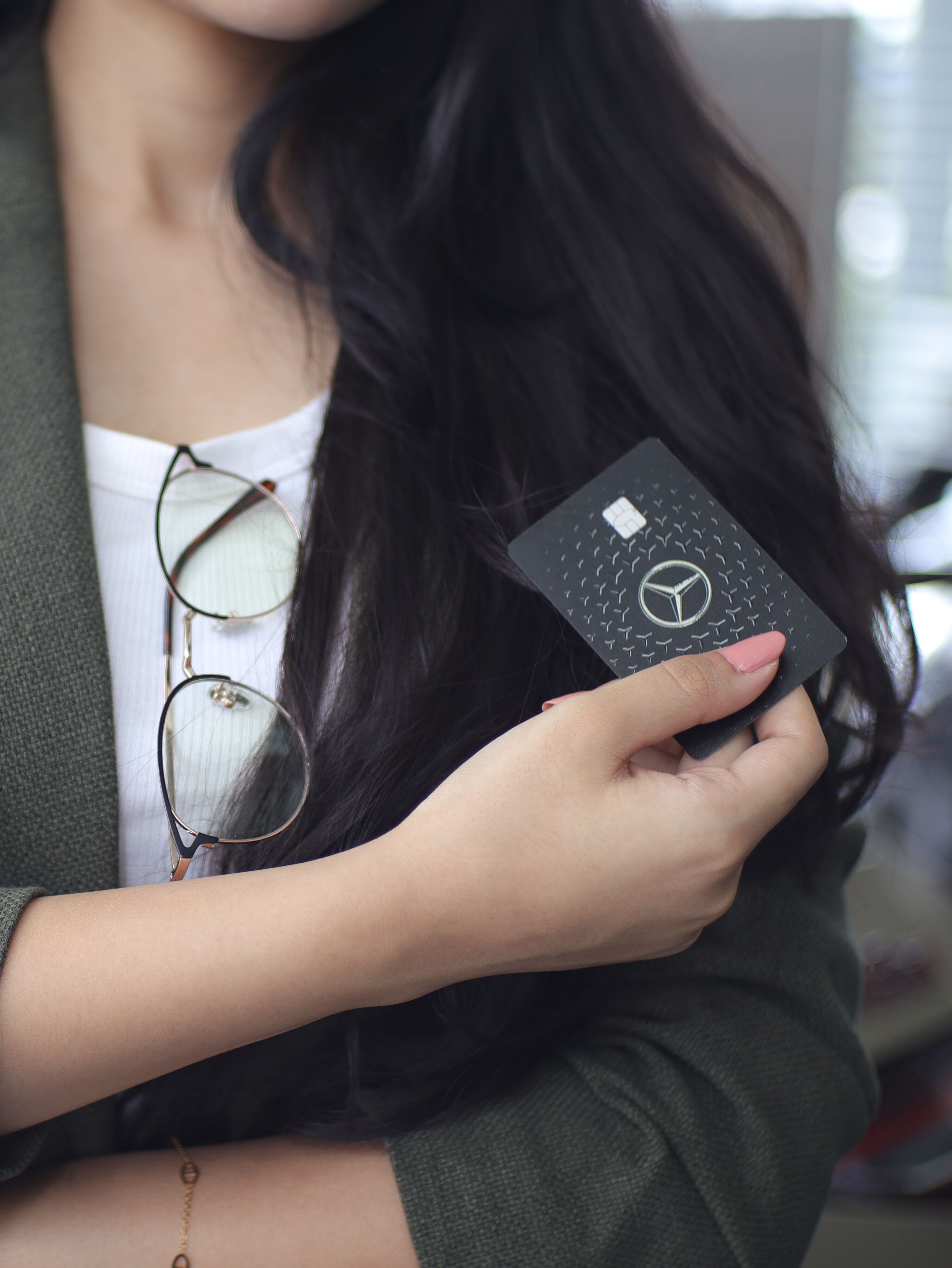 A woman holding a Mercedes-benz card