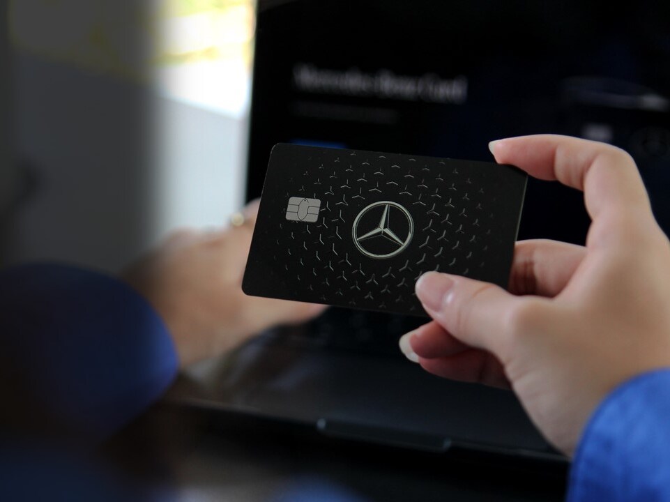 A woman holding a Mercedes-Benz Card 